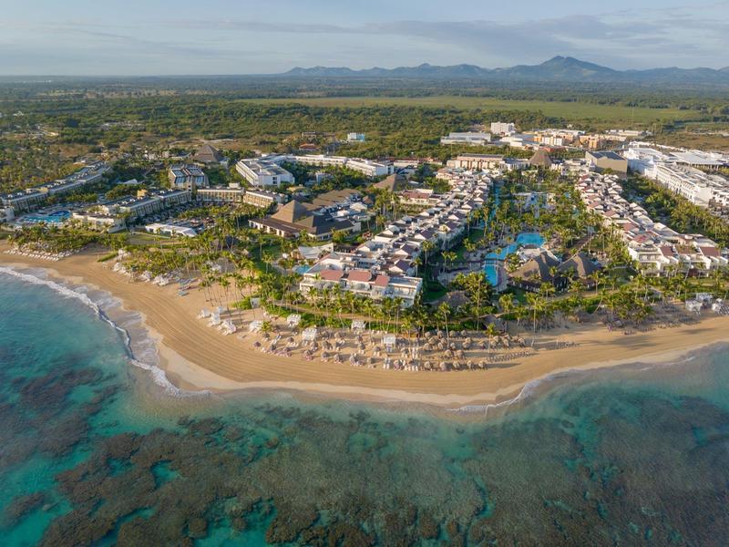 Luxuriöses Hotelresort mit weitläufigen Pools, Palmen und weißem Sandstrand am türkisfarbenen Meer.