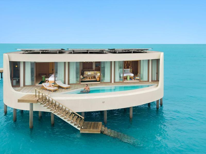 Luxuriöse Überwasser-Villa mit Pool, moderner Glasfassade und Treppe ins türkisfarbene Meer.