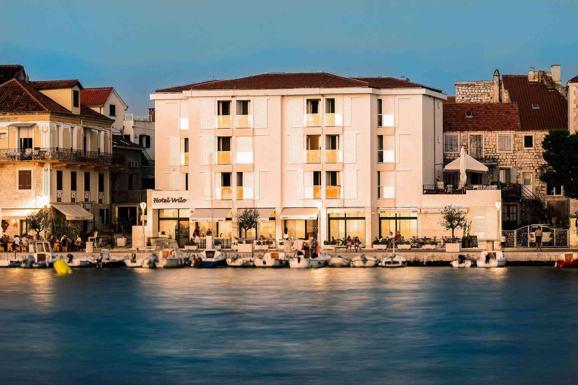 Modernes Hotelgebäude am Wasser mit Terrasse und ruhiger Abendstimmung im Urlaubsort.