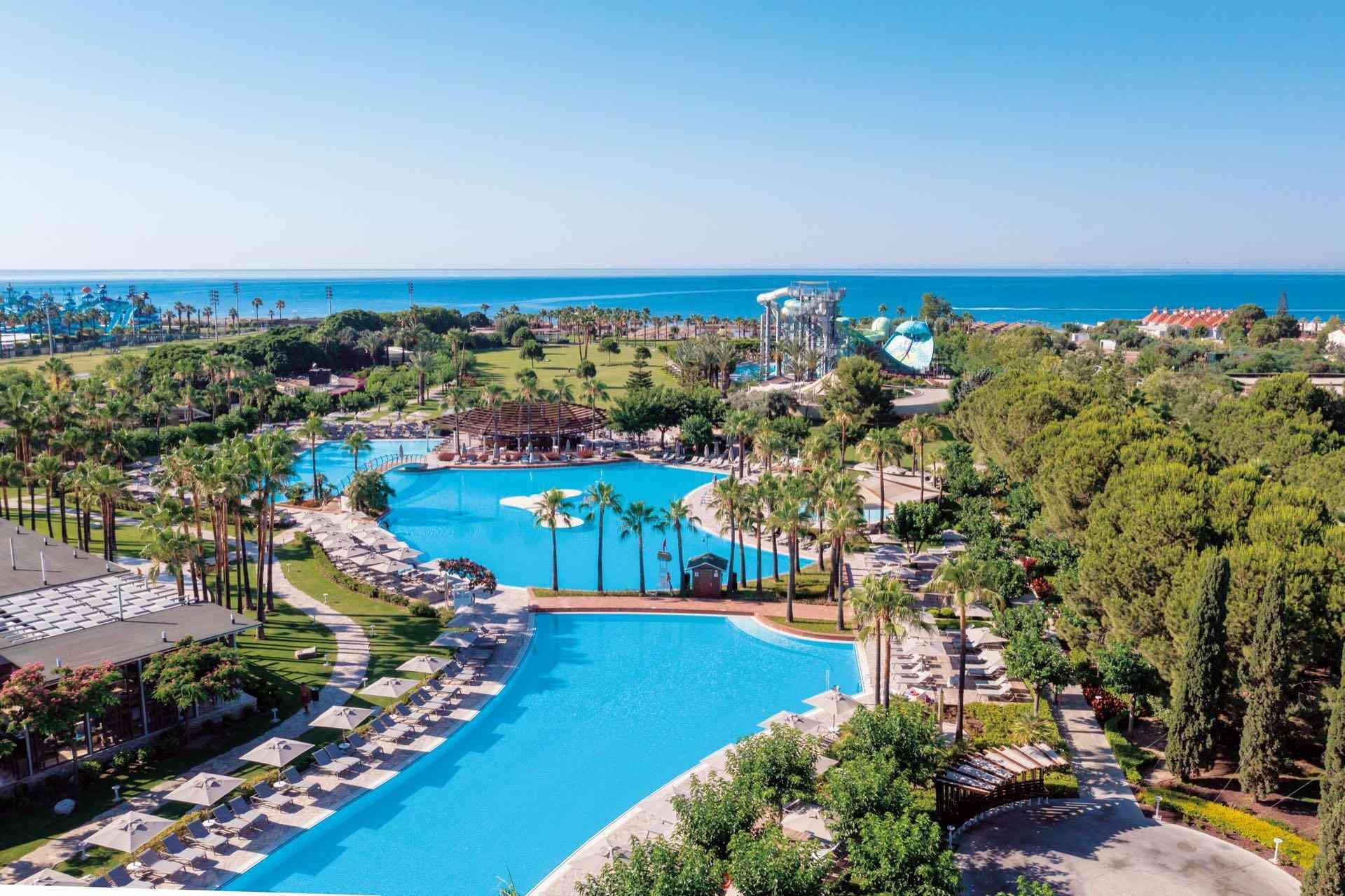 Große Hotelanlage mit weitläufigem Pool, Wasserrutschen und direktem Blick auf das Meer.