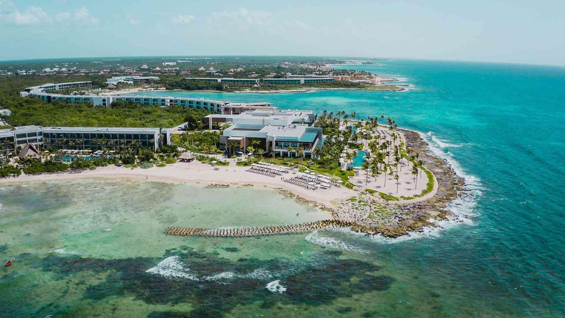 Luxuriöses Strandhotel mit Pool, Sandstrand und türkisfarbenem, klarem Meerwasser.